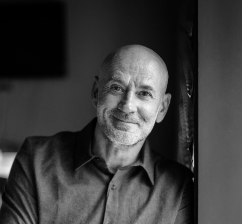 Homme souriant appuyé sur un mur